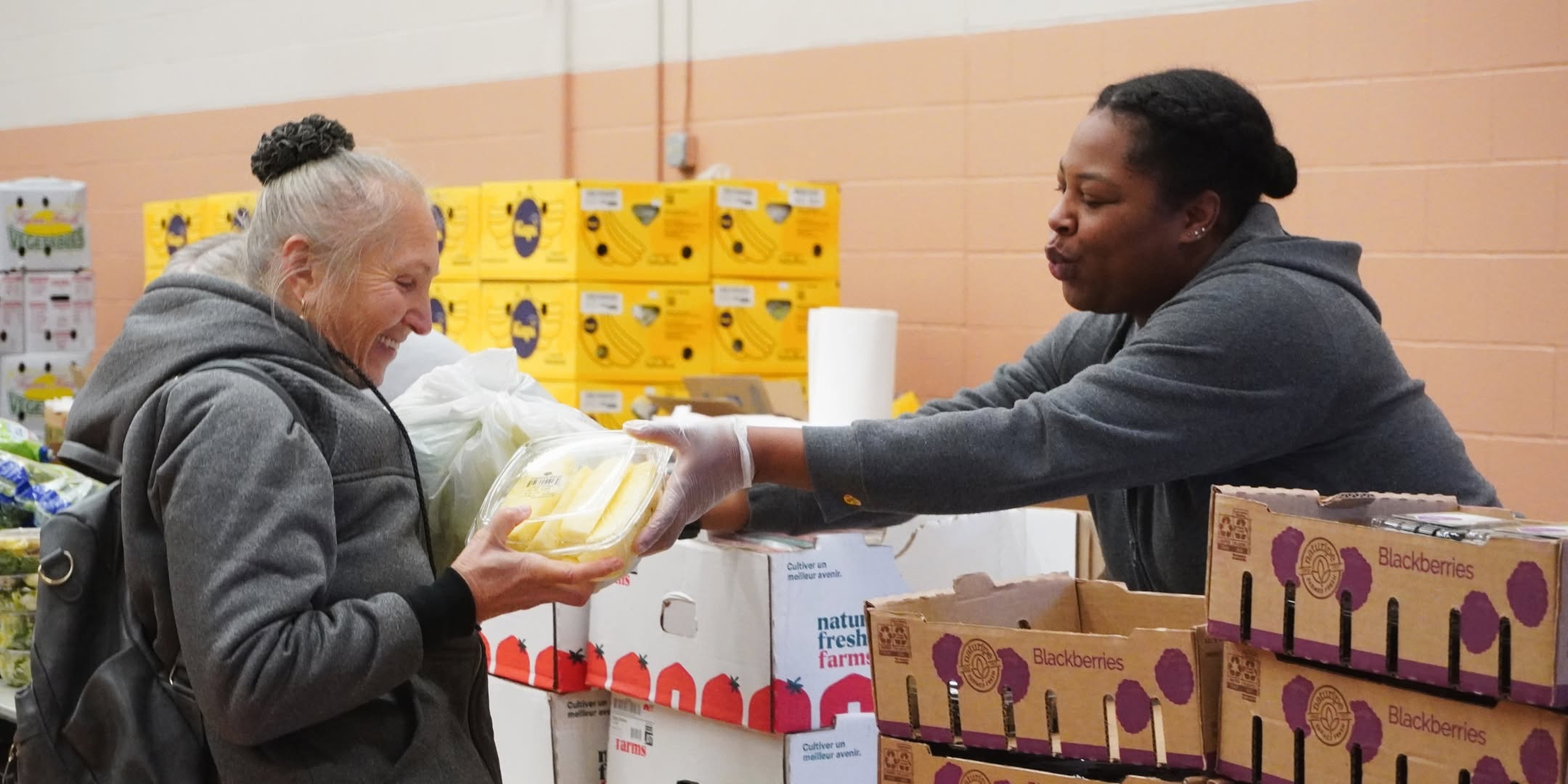 A Salvation Army volunteer passes a visitor some fresh produce.